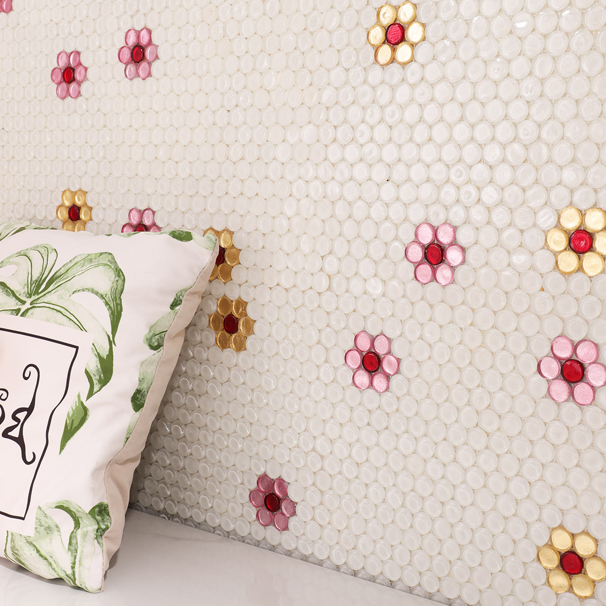Floral mosaic tile on the wall with pillows visible