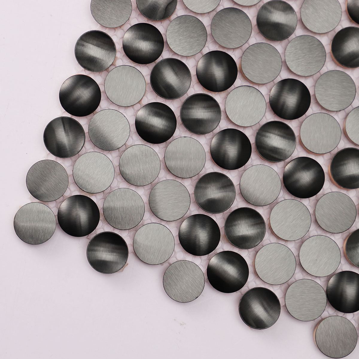 Detailed close-up of 3D black penny round metal mosaic tiles