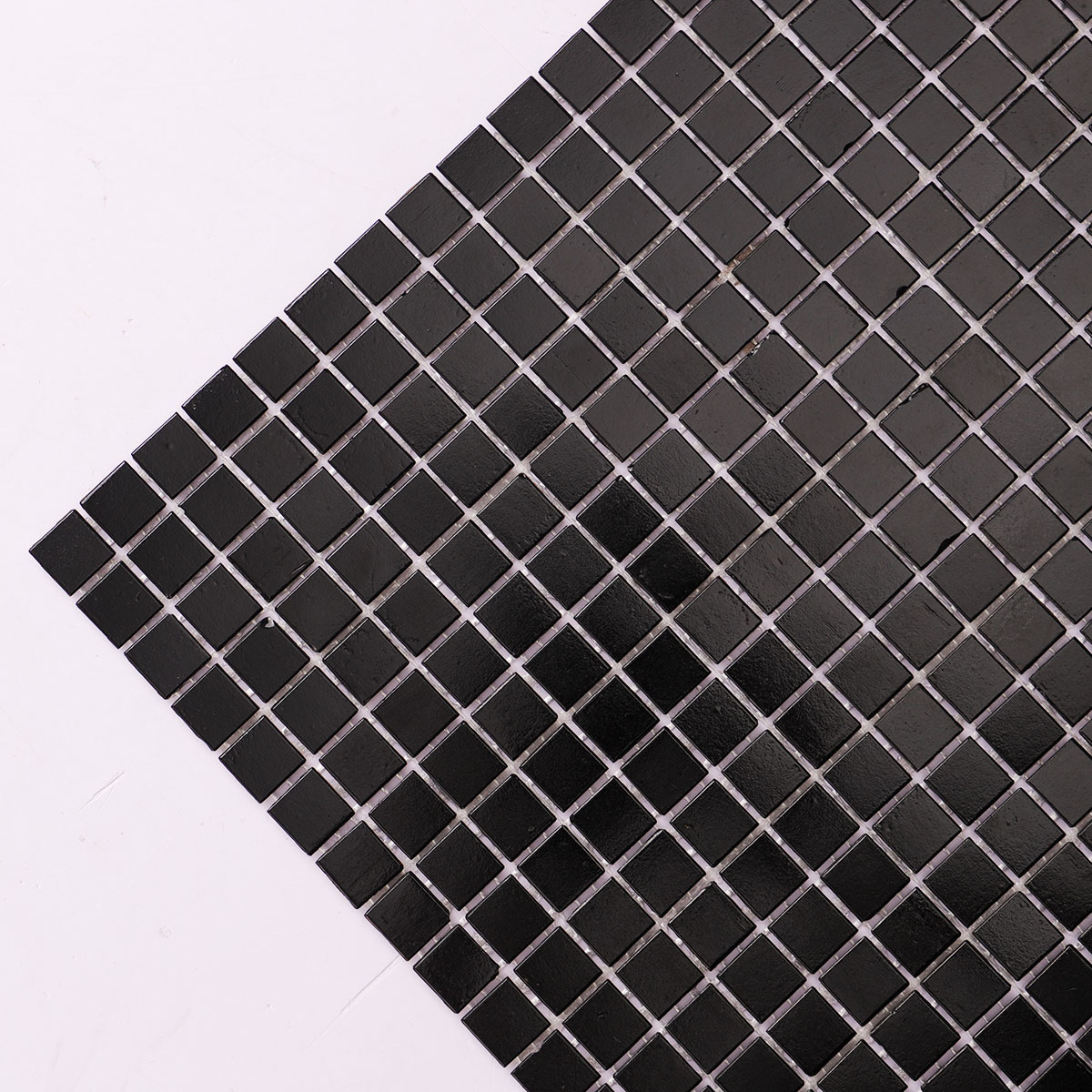 Macro close-up of black square fired earth glass mosaic tiles 15mm x 15mm.