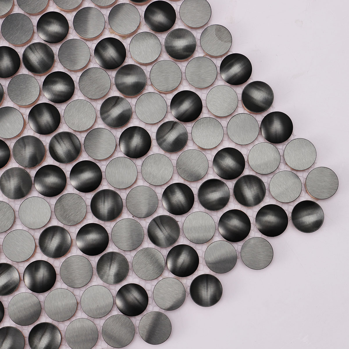 Close-up of 3D black penny round metal mosaic tiles.