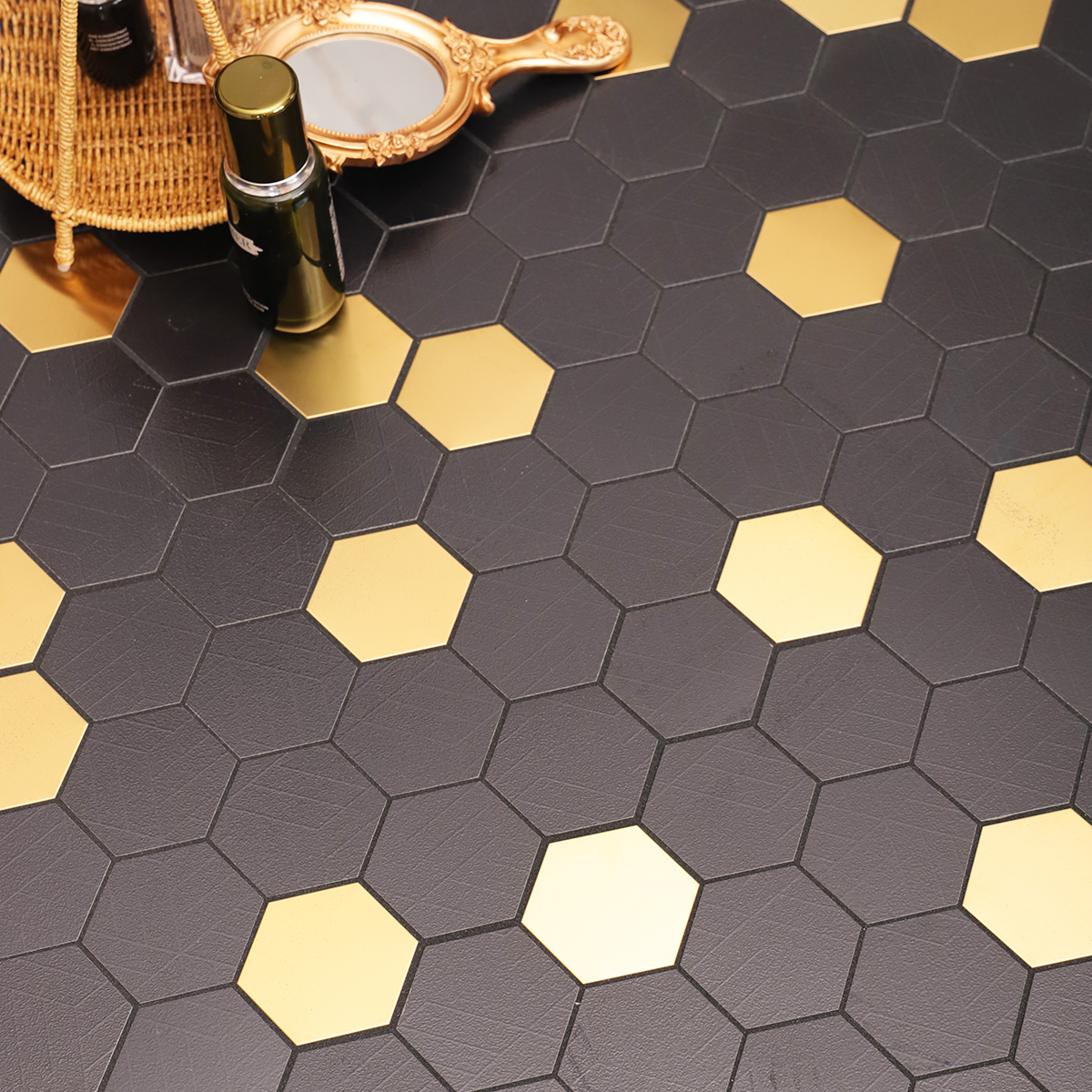 Black and Gold Hexagon Mosaic Tiles on the floor, decorated with skincare products and a mirror