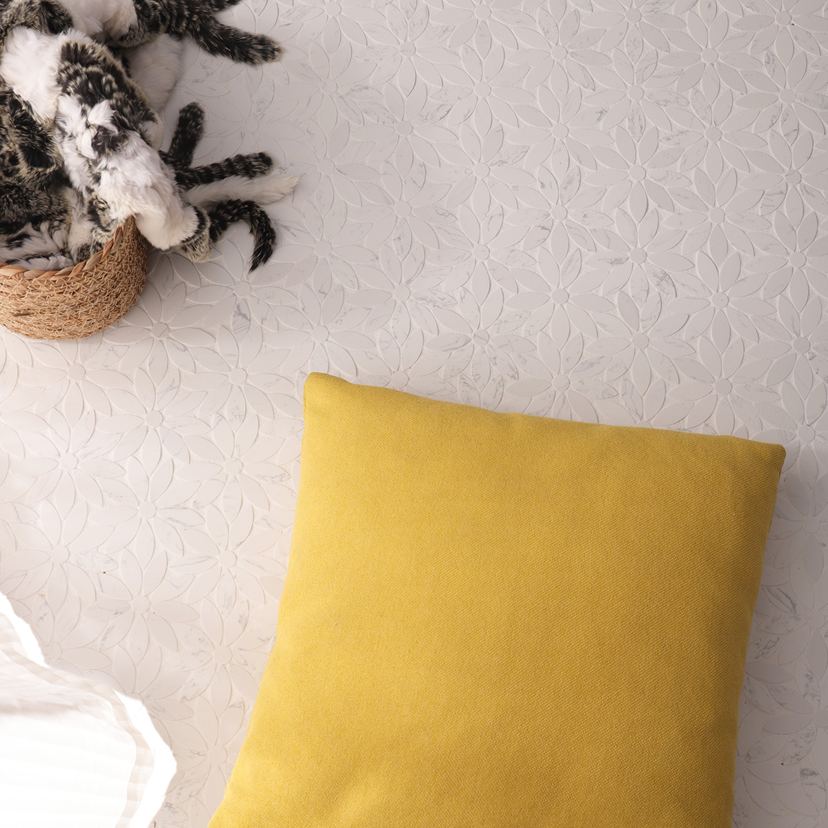 Top view of daisy-patterned marble mosaic tile with yellow cushion and decorative elements.