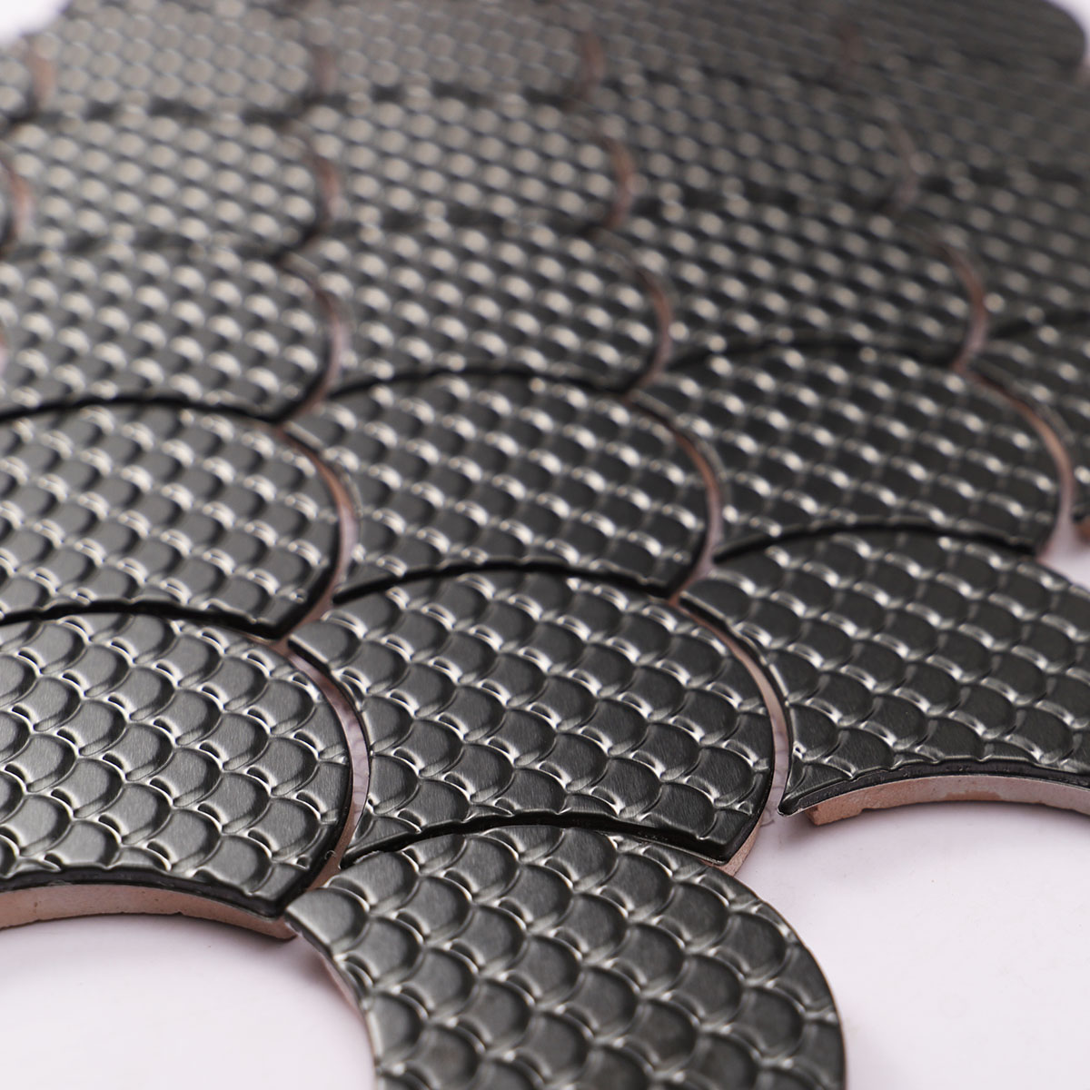 Close-up of black metal fish scale pattern mosaic tiles.