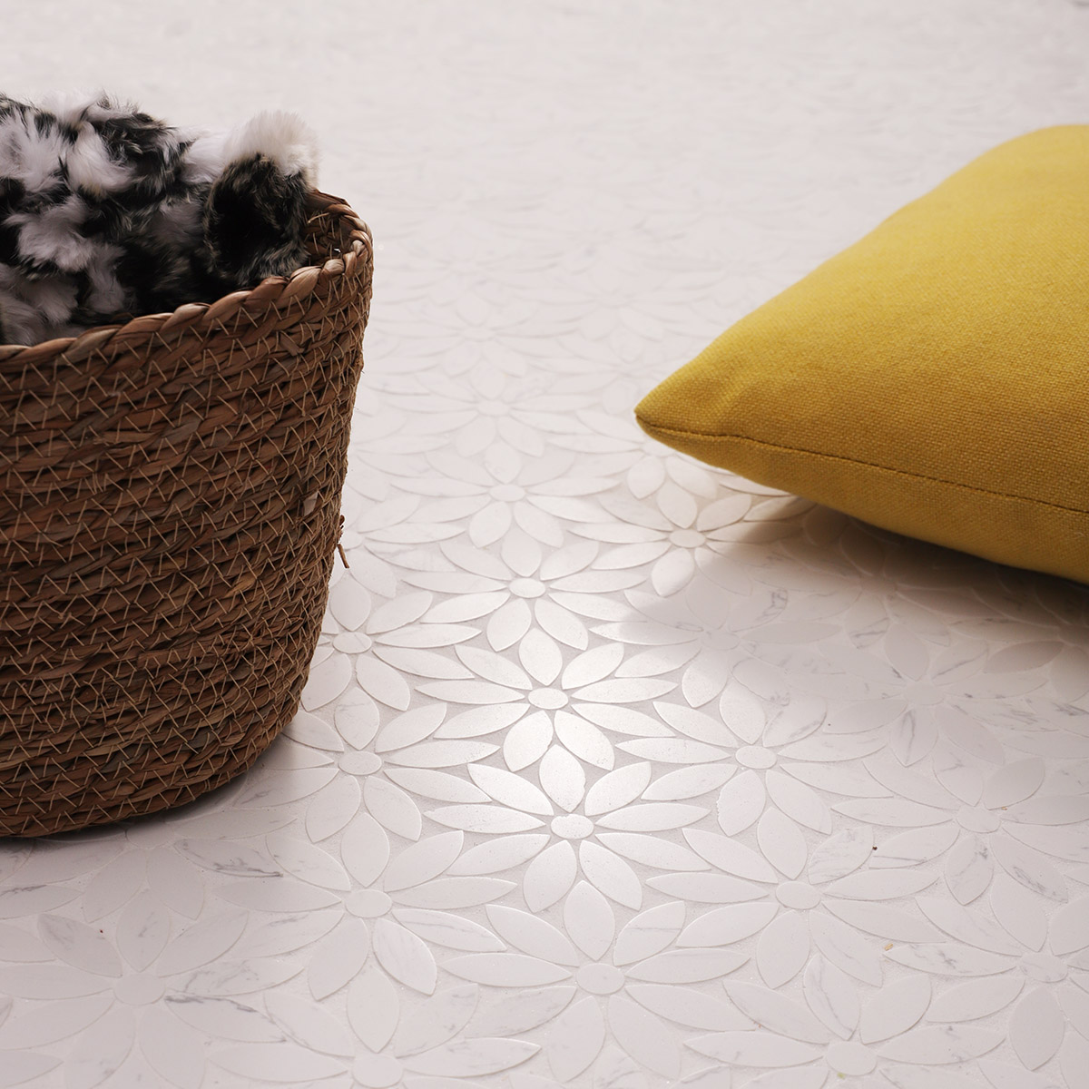 Daisy-pattern marble mosaic tile floor with a woven basket and a yellow cushion.