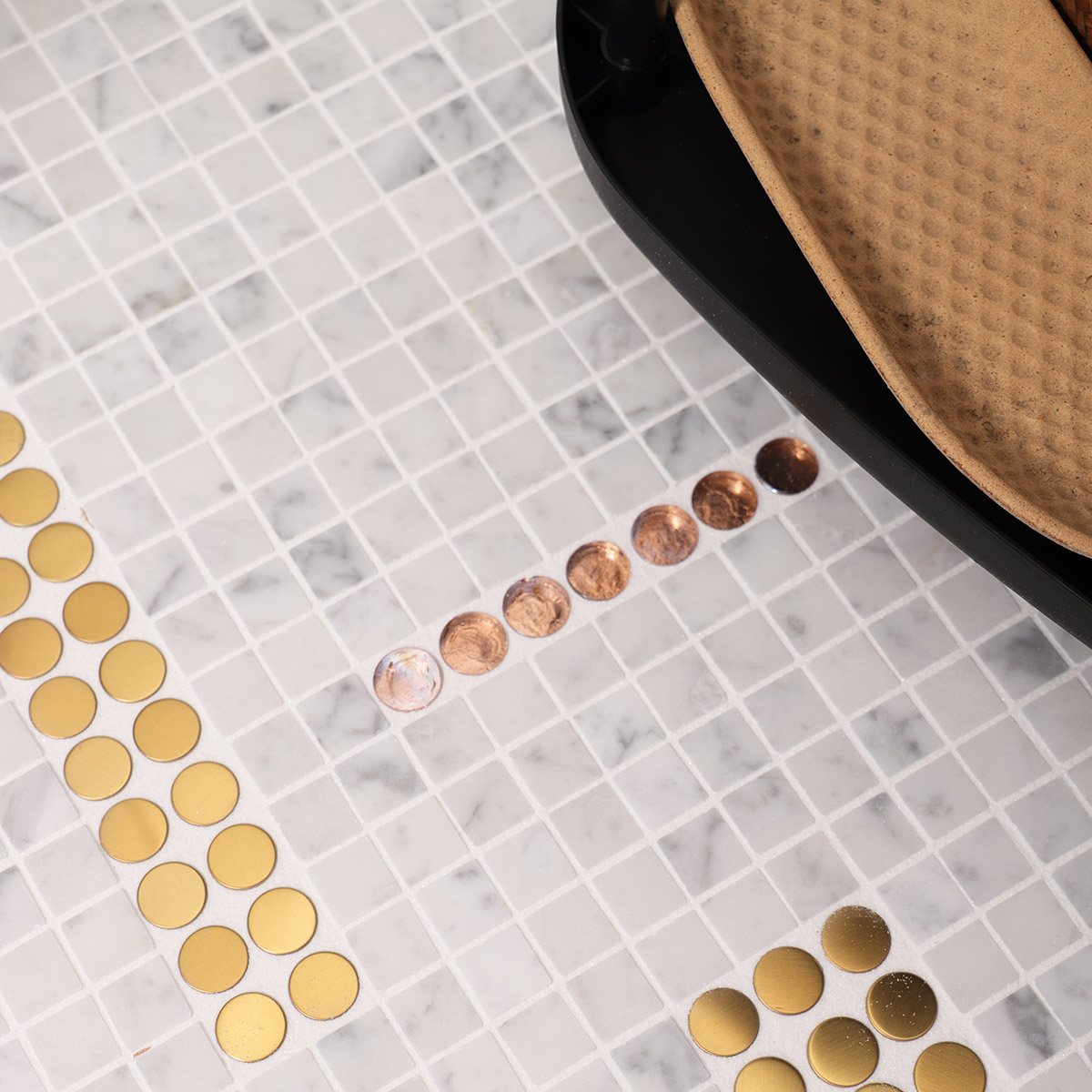 Close-up of white marble mixed with metal and glass mosaic floor tiles