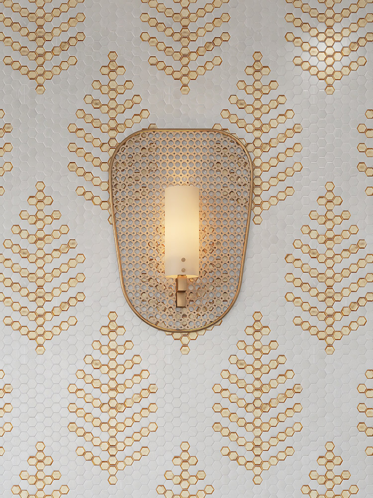 White and gold hexagonal mosaic tiles with a woven texture and a wall lamp