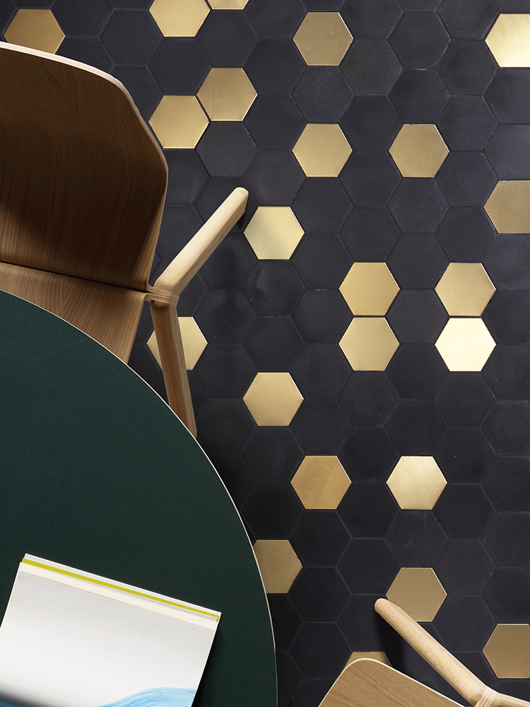 Black stone and gold stainless steel mosaic floor in a dining room.