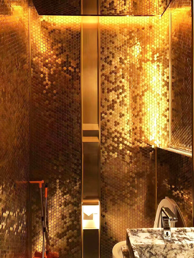 The hexagonal metal mosaic tiles bring a high-end, luxurious feel to the bathroom, adding elegance and sophistication to the space.