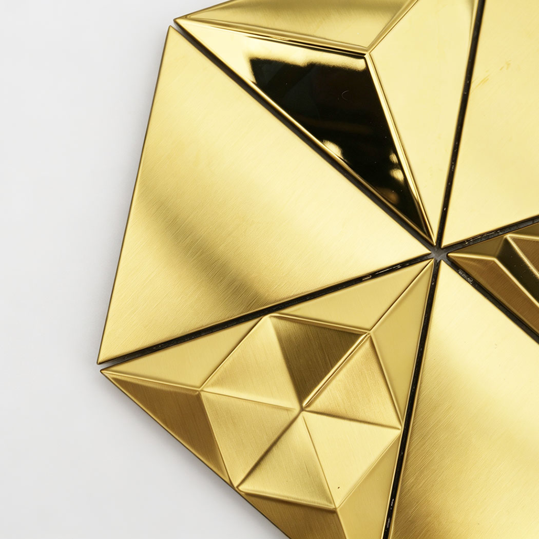 Close-up of gold 3D wall tiles with geometric triangle detail