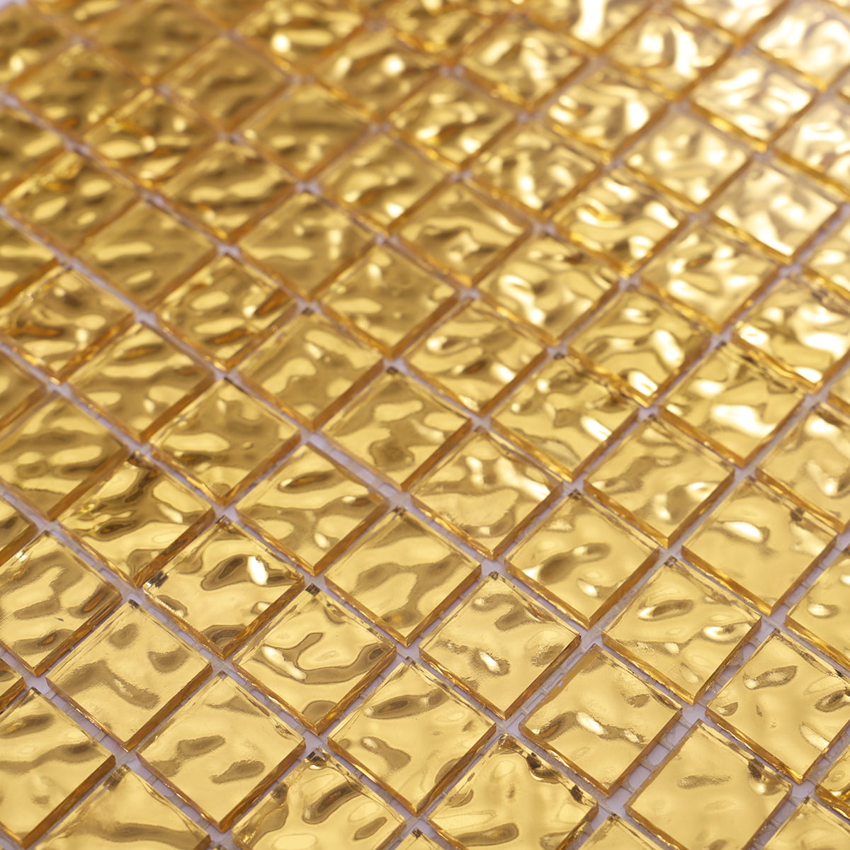 Close-up of 24K gold mosaic tiles with a wavy surface for luxurious applications.