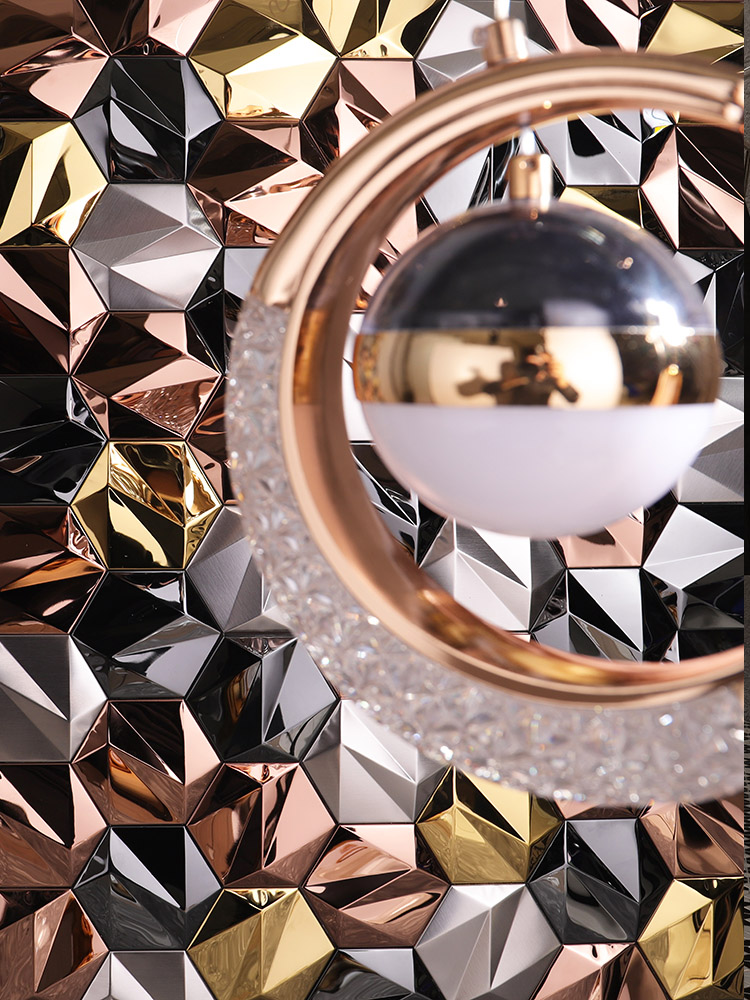 Metal hexagonal 3D mosaic tiles with a crescent-shaped pendant light creating light-shadow effects
