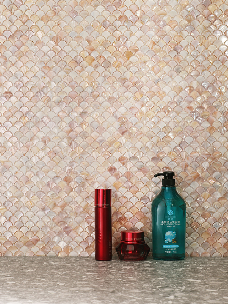 The fish scale shell mosaic adds a touch of elegance to the bathroom walls, beautifully complemented by gray floor tiles for a modern look