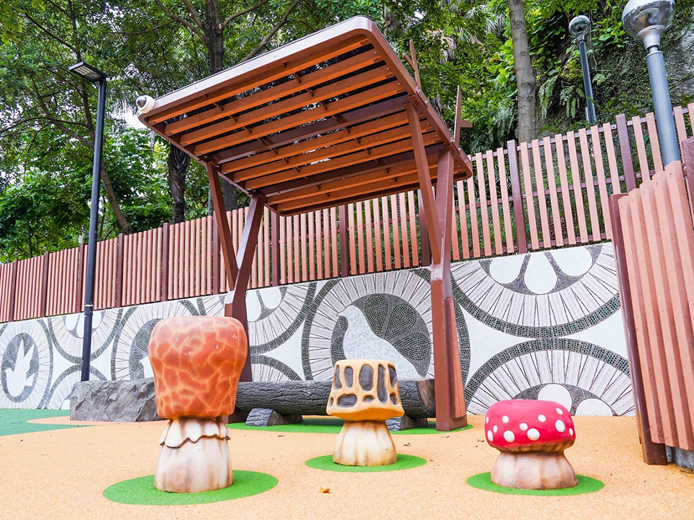 Mosaic mural in a children's park, showcasing vibrant designs and playful themes on the wall.