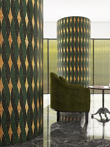 Green and gold mosaic tile wall with intricate geometric pattern. 