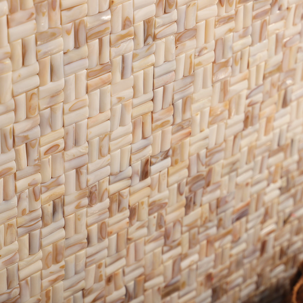Side angle of 3D beige mother of pearl basket weave mosaic wall surface.