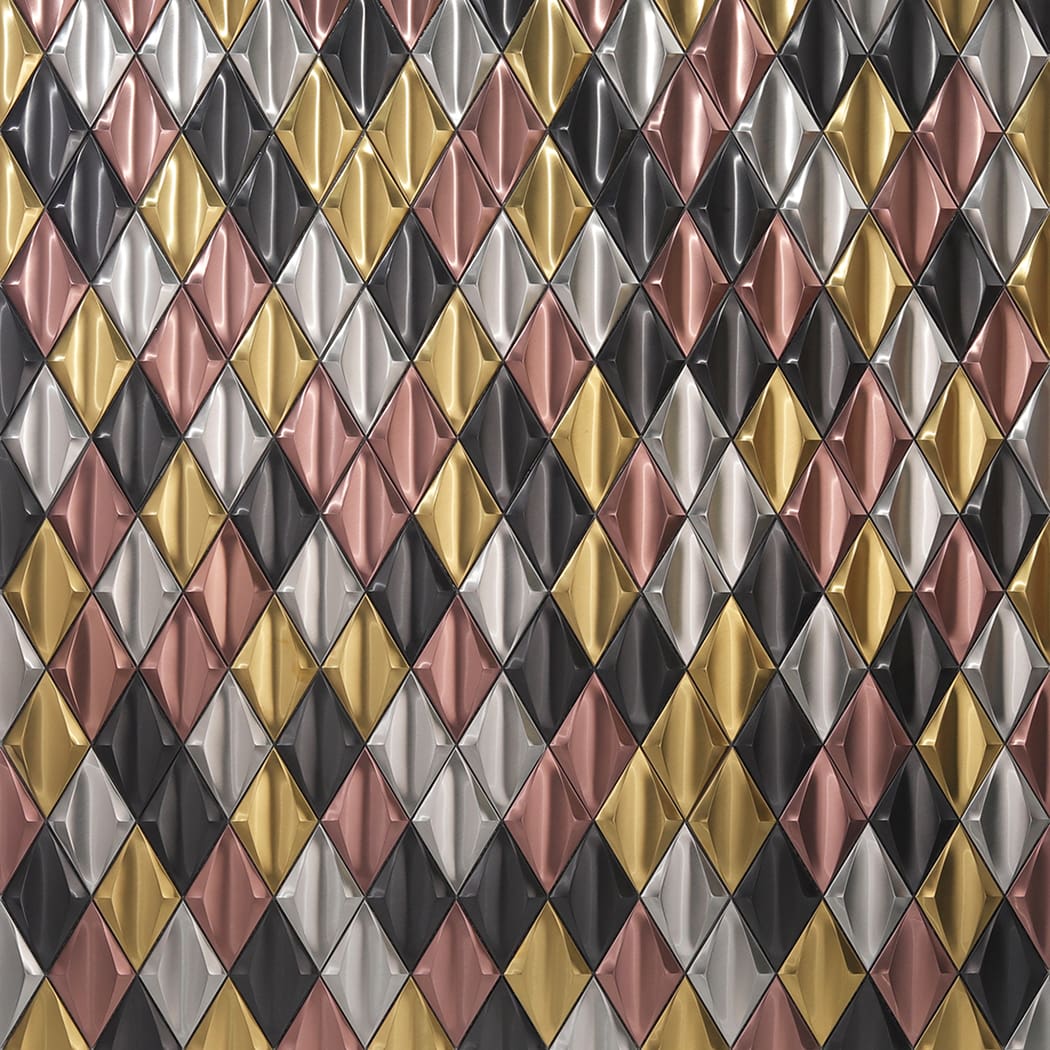 A wall covered in a repeating geometric pattern of multicolor 3D diamond metal tiles.