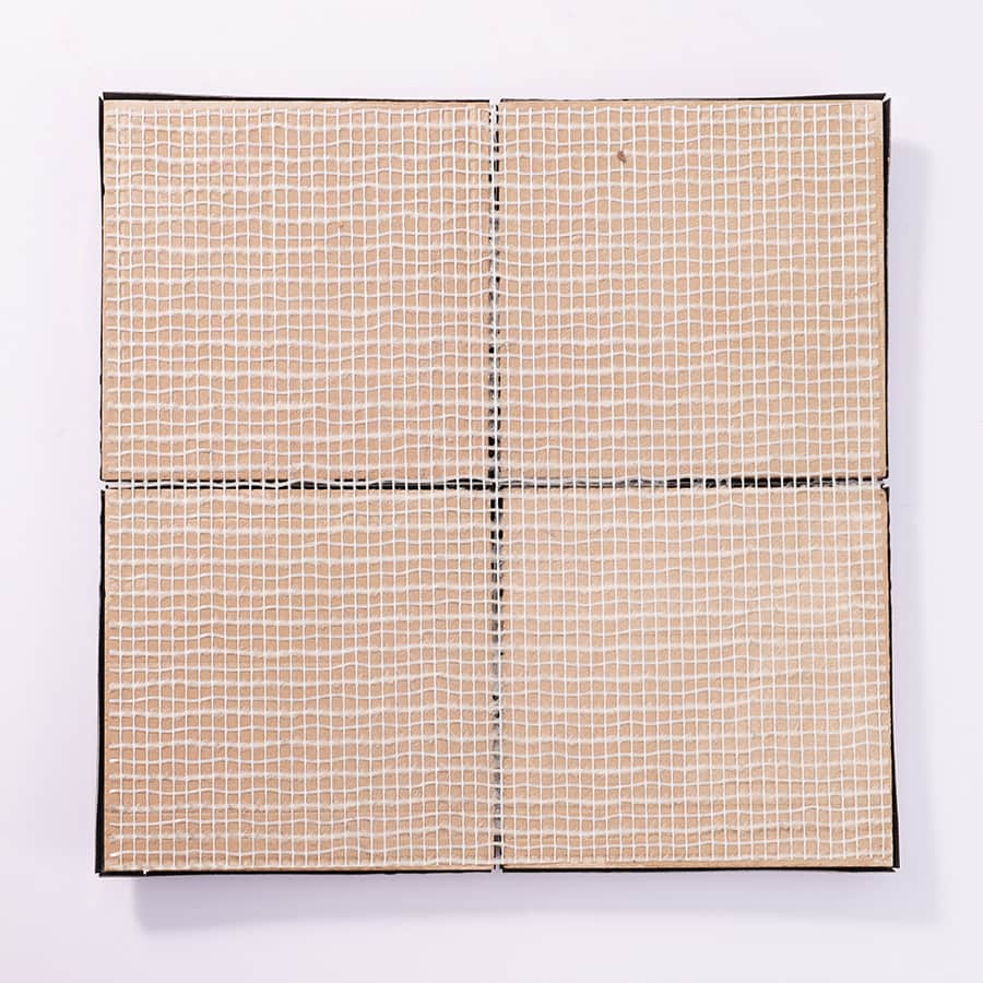 Backside view of 3D mosaic tile showing mesh mount for easy wall application.