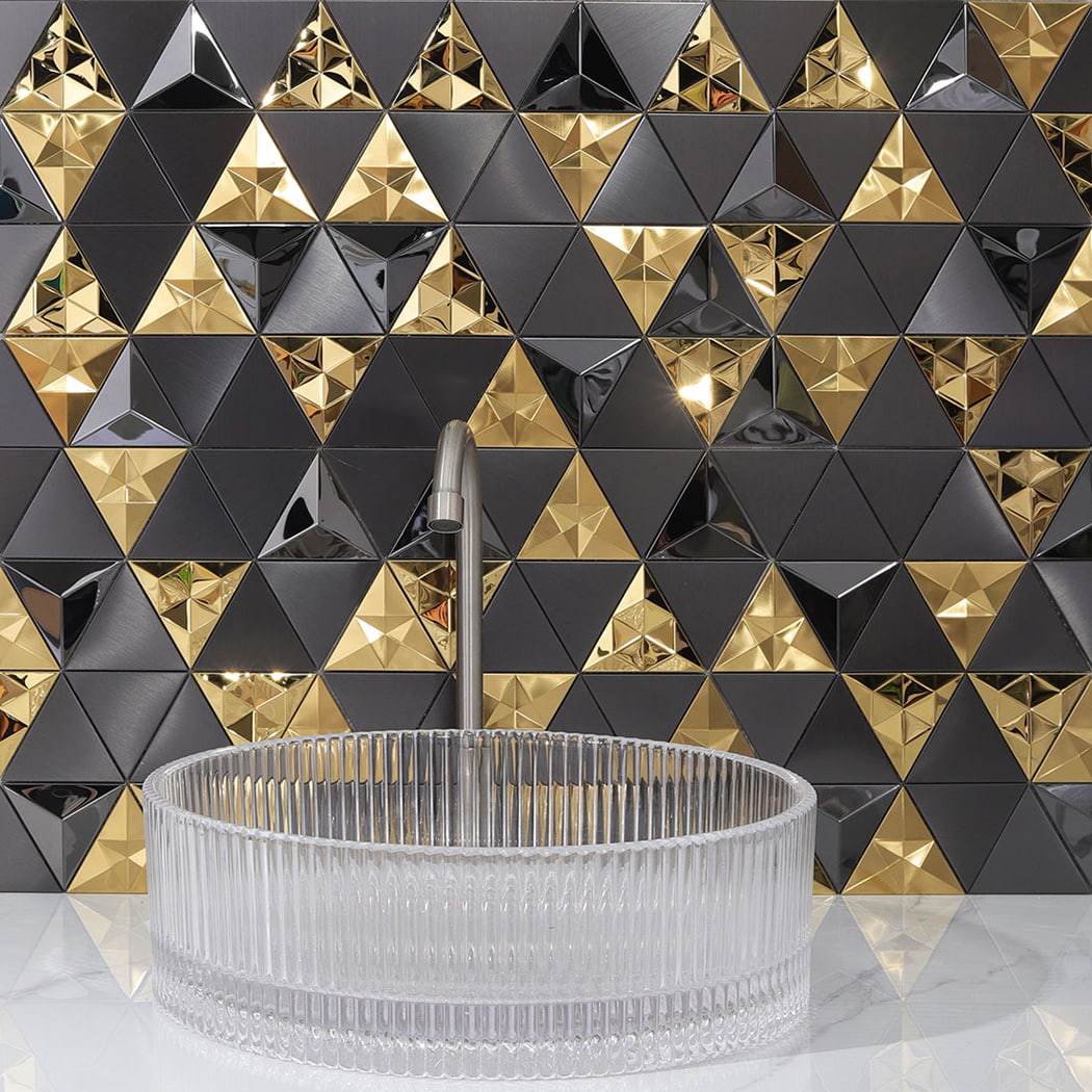 Modern 3D triangle metal mosaic backsplash behind a clear glass washbasin.