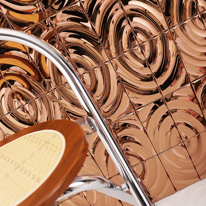 Rose gold swirling mosaic tiles with a modern chair in the foreground