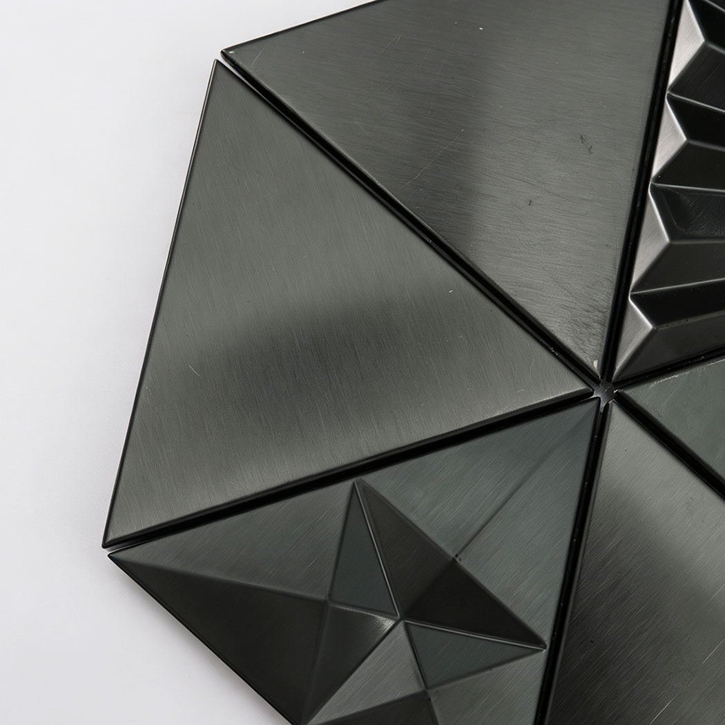 Close-up of black 3D bathroom tiles in a triangle mosaic design