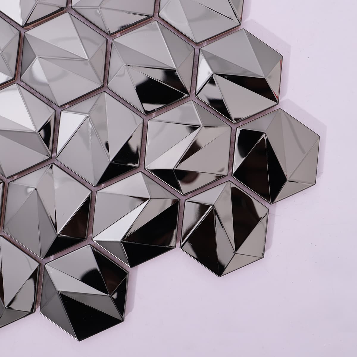 Faceted black metal hex tiles with bold modern angles in a close-up view