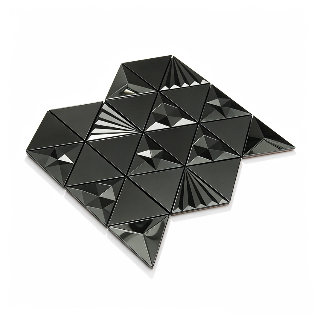 Angled view of a black 3D tile backsplash in a triangle mosaic pattern
