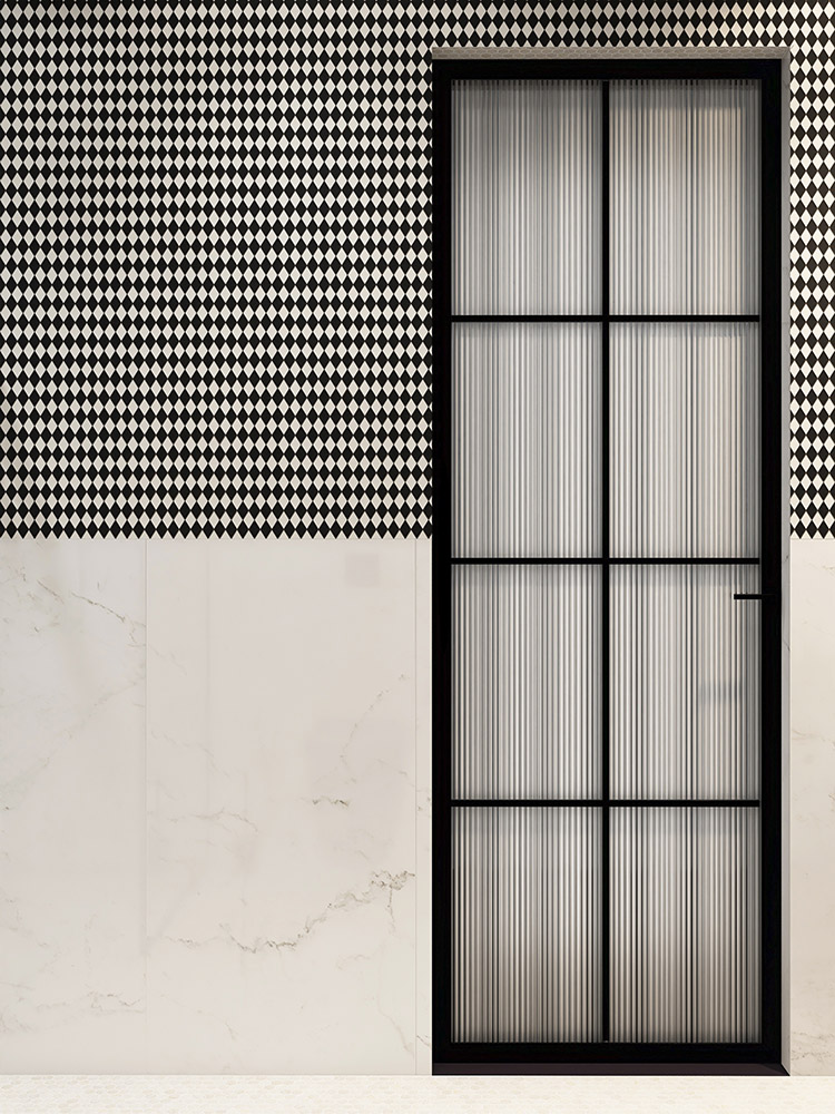 Black and white diamond mosaic half-wall with a black-framed glass bathroom door.