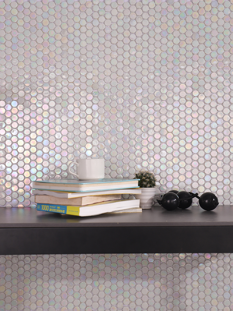 The iridescent white round mosaic tiles on the study wall bring a refined, elegant vibe, perfectly paired with books on the desk for a cozy workspace.