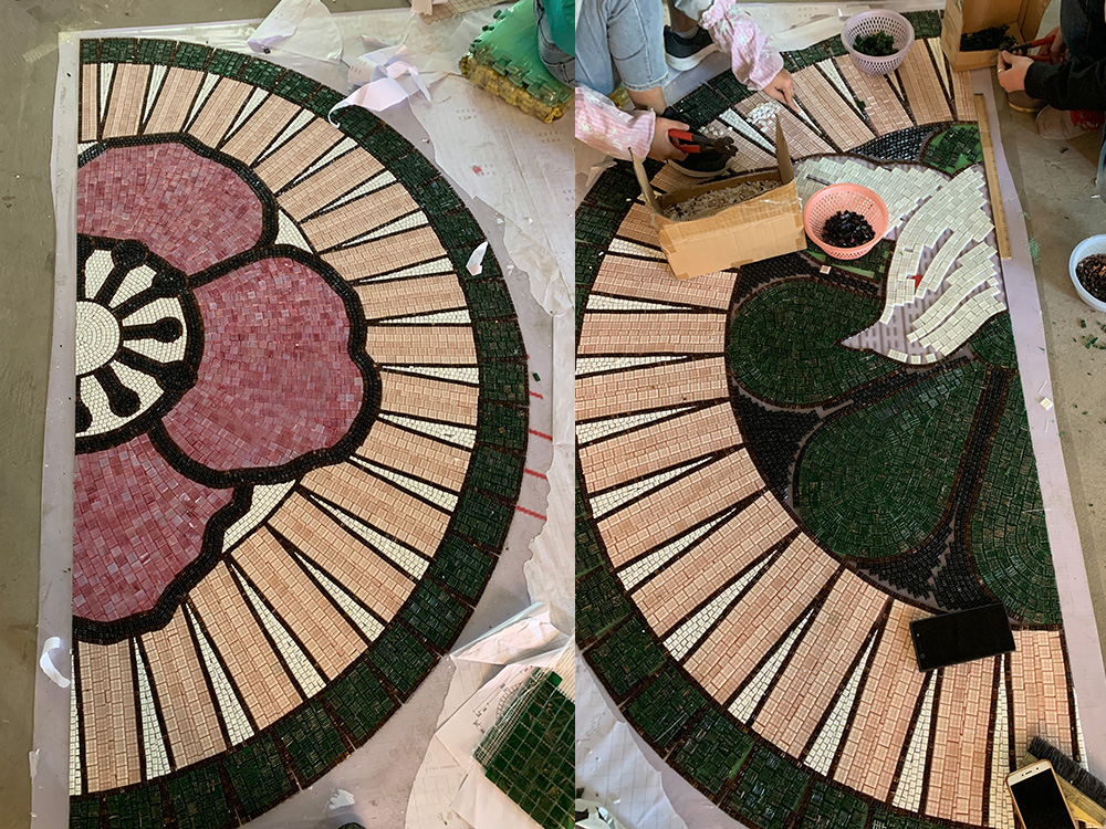 Factory workers creating a mosaic mural for a children's park, showcasing colorful tile assembly.