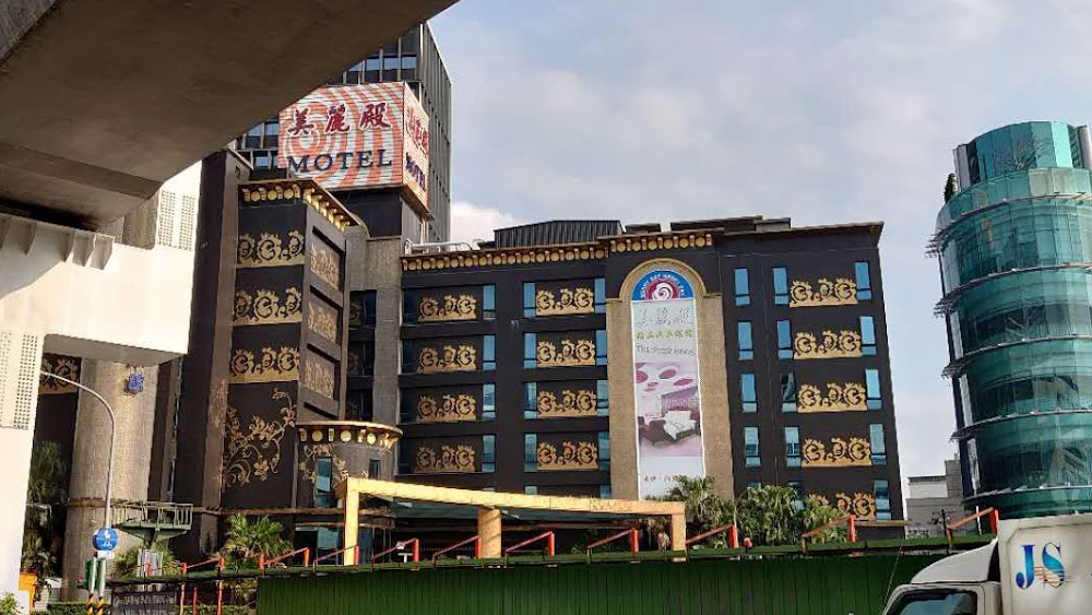 Distant view of the hotel exterior with visible mosaic patterns on the facade.