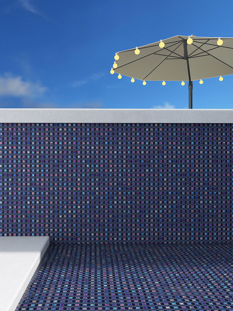 Blue iridescent glass mosaic tiles in the pool with a sunshade umbrella outside.