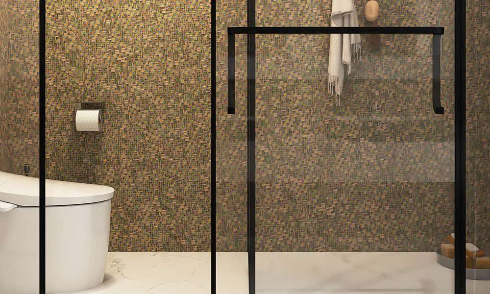Olive green glass mosaic tiles on the bathroom wall next to a white toilet.