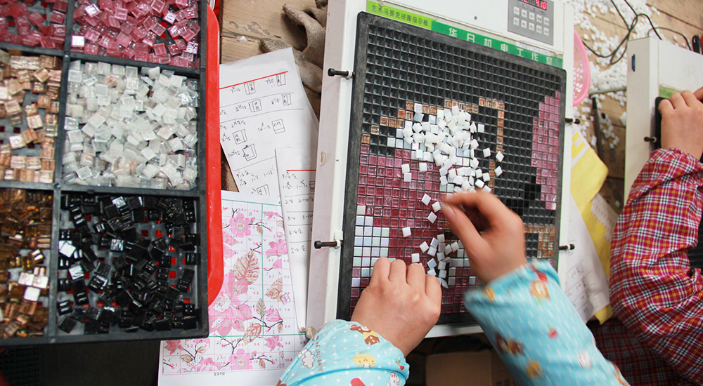 Pixel mosaic tiles in the process of being made.