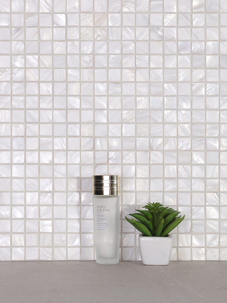 The white shell mosaic tiles add a natural, elegant touch to the bathroom wall, enhancing the space with a subtle, organic beauty.