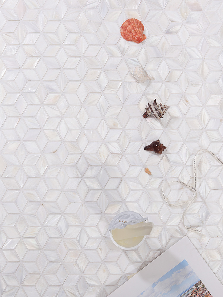 Diamond white mother of pearl mosaic tiles with seashells nearby.