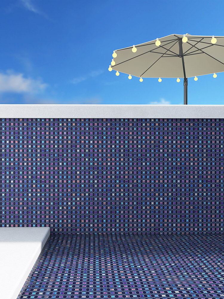Blue iridescent mosaic tiles in the pool with a sunshade umbrella outside.
