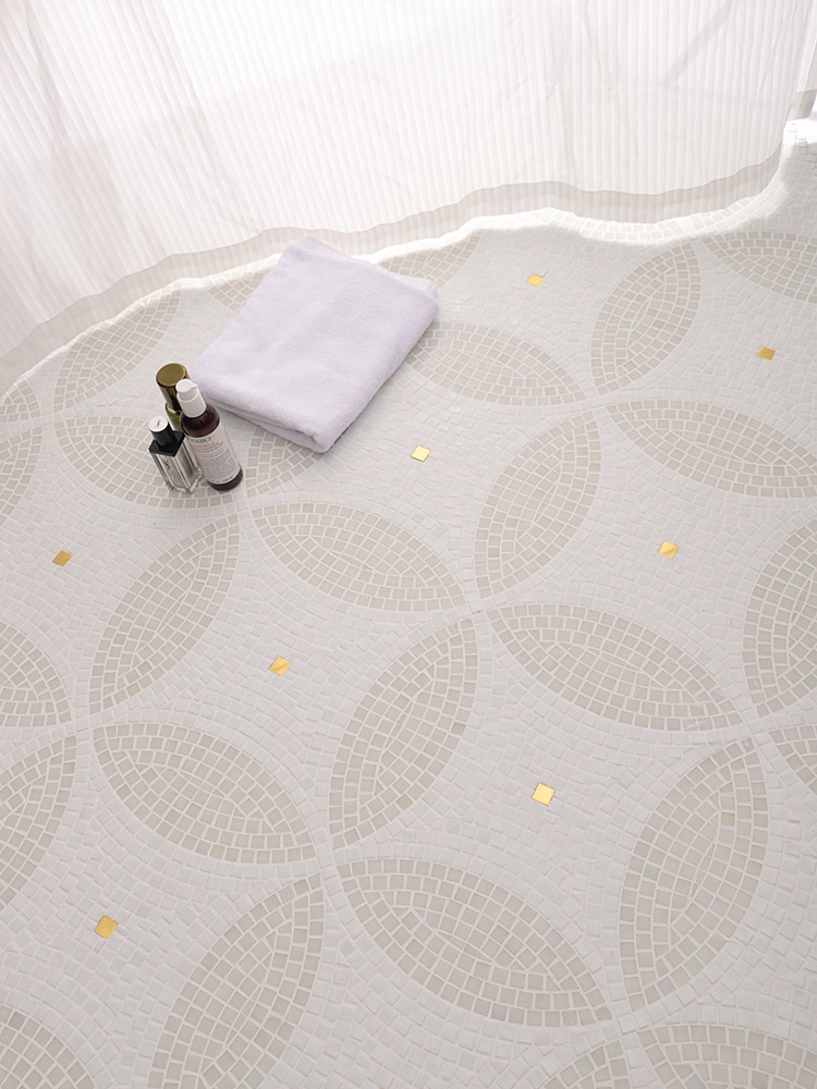 Gray and white four-leaf clover handmade patterned glass mosaic tiles on the floor.