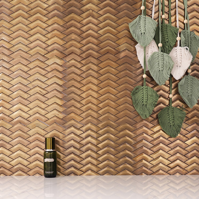 Gold vertical herringbone metal wall tiles with macrame leaf decor and serum bottle 