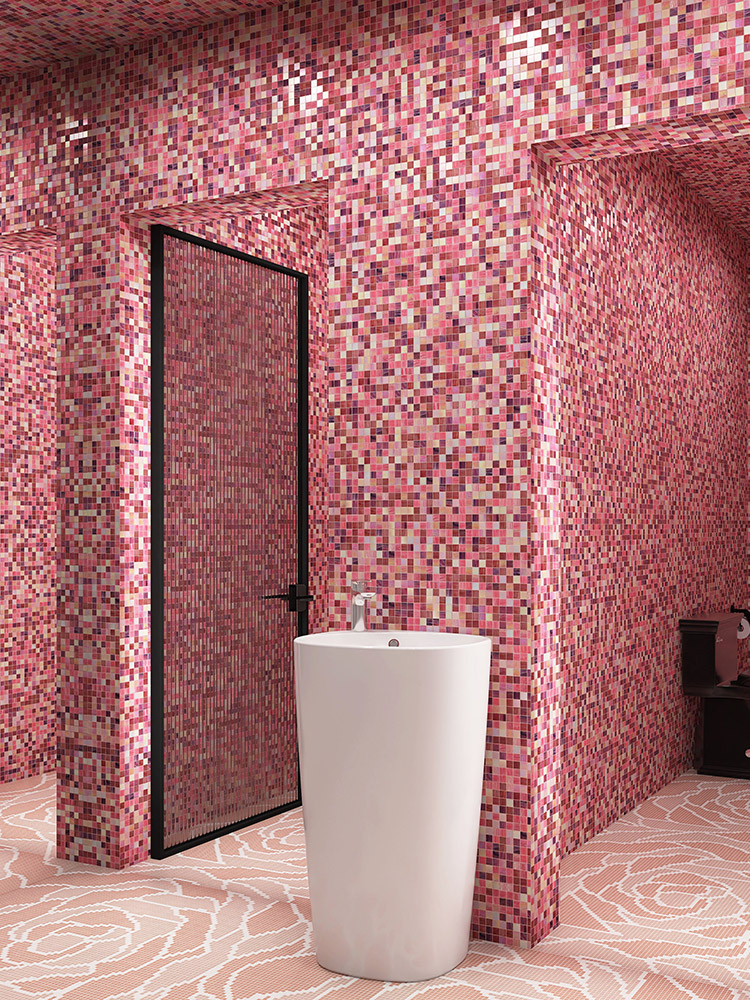 Pink glass mosaic tiles on the wall, rose pixel mosaic floor tiles, with a white sink in front.