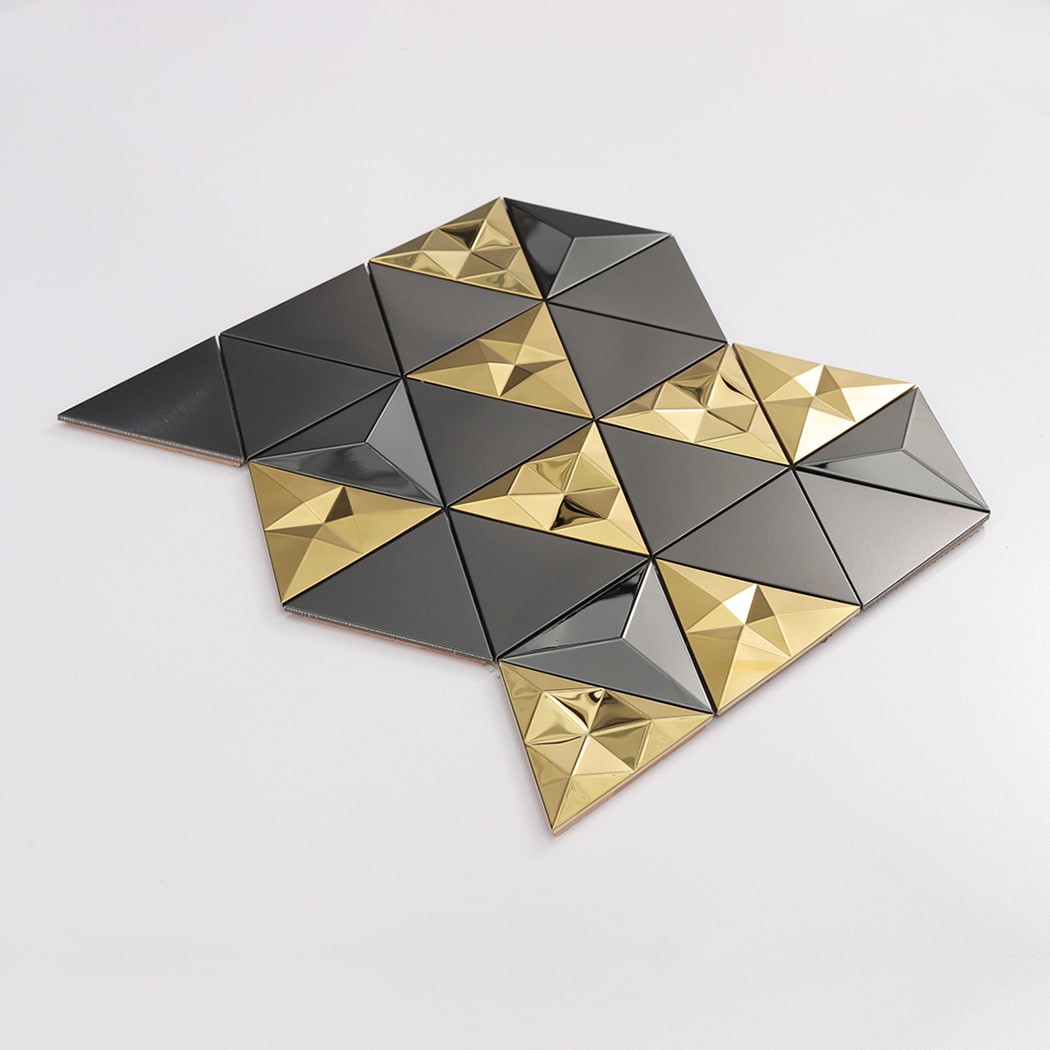 Angled perspective of a black and gold 3D triangle metal mosaic tile sheet.