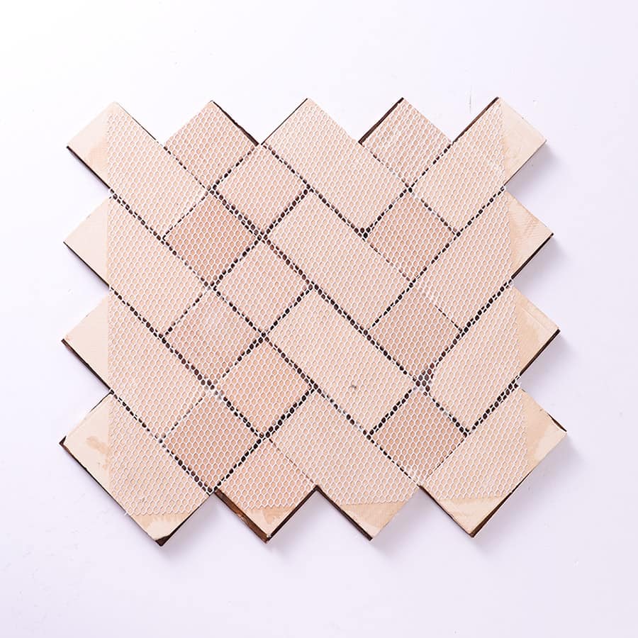 Back view of antique copper metal mosaic tile with mesh backing.