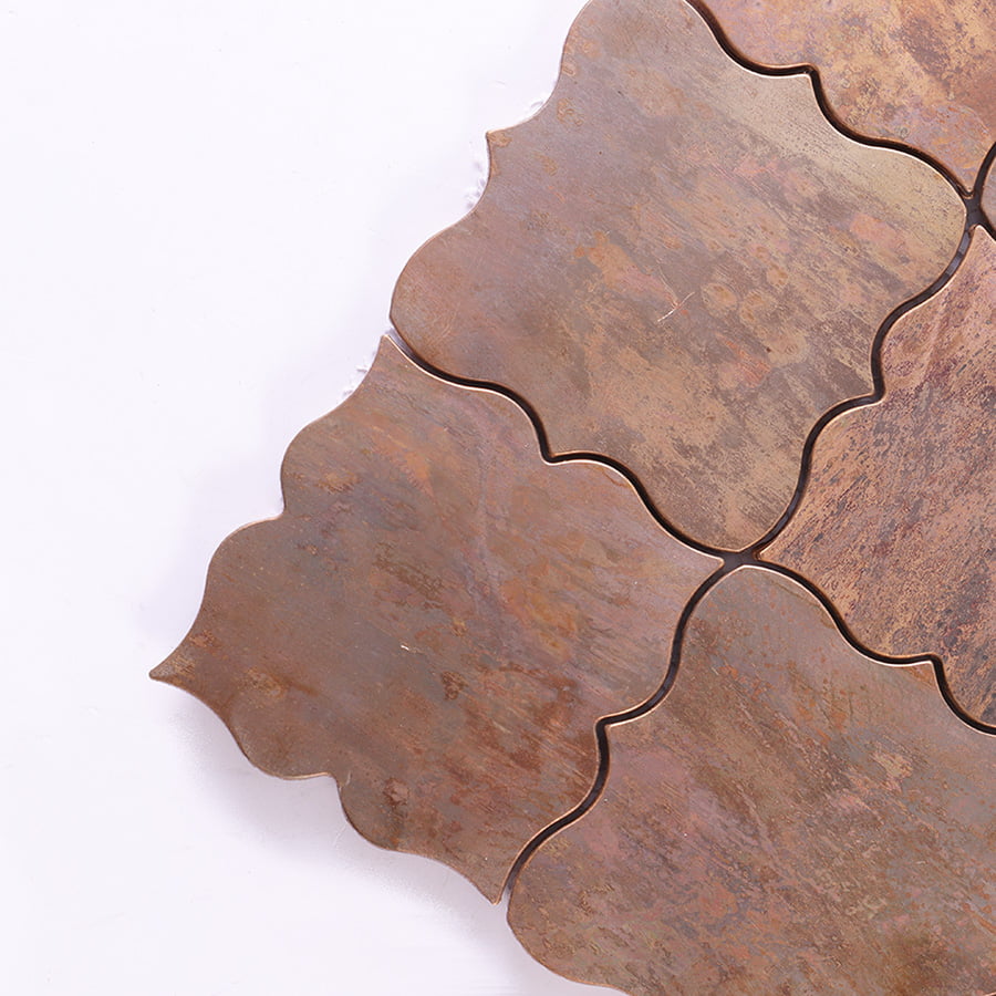 Close up of antique bronze arabesque mosaic tile corner showing curved shape detail