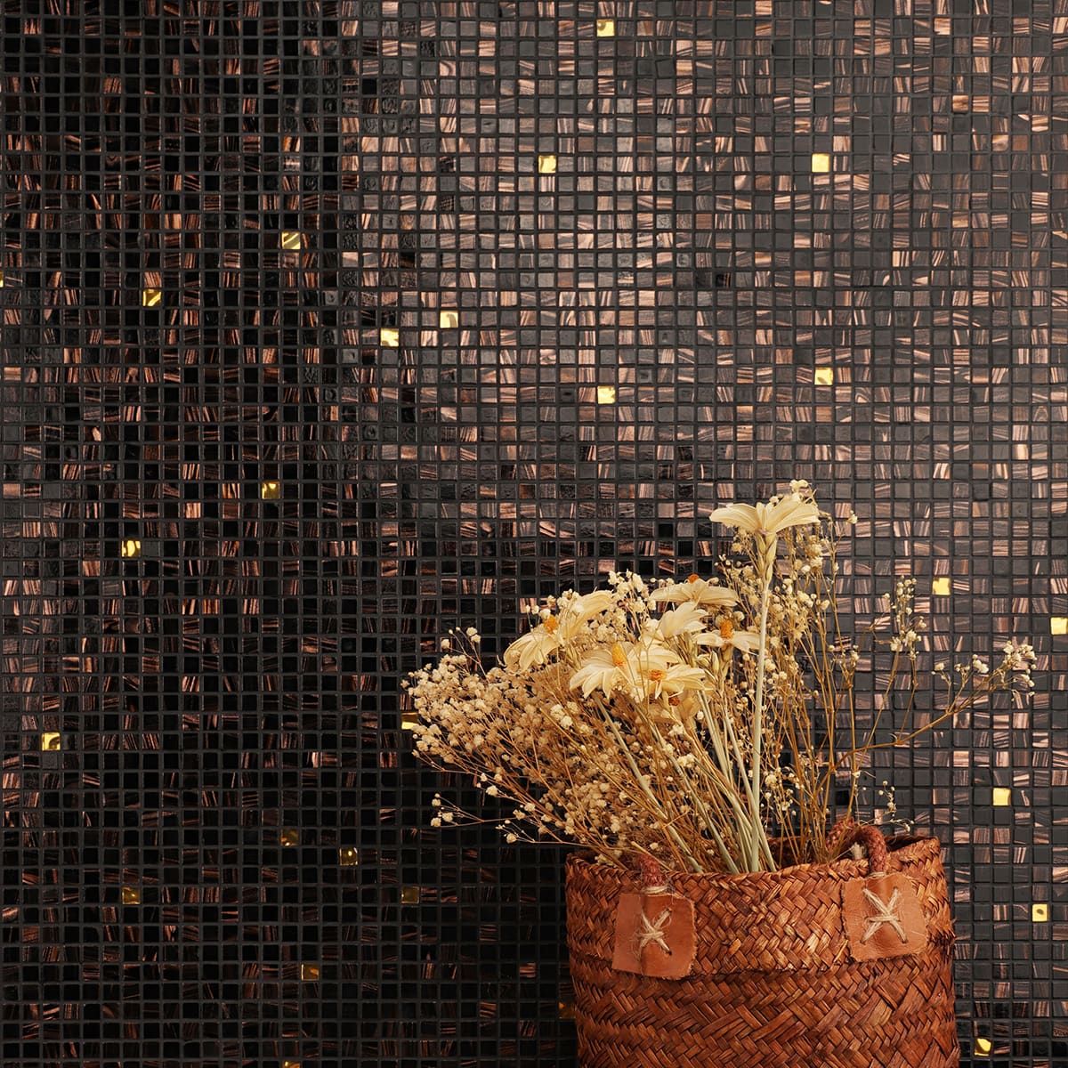 Artistic wall design with black mosaic tiles, bronze swirls, and gold glass details