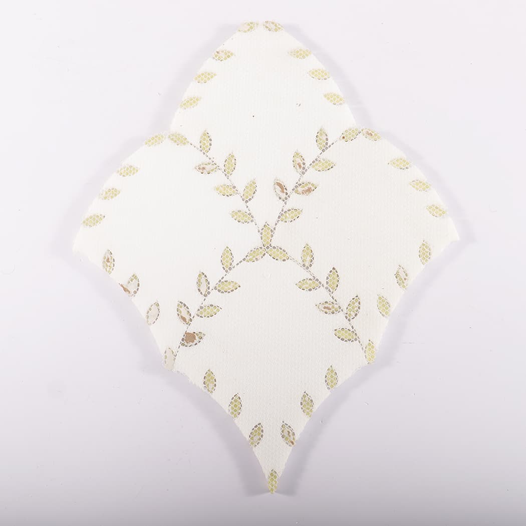 Backside view of a mosaic tile with a leaf pattern mesh backing.