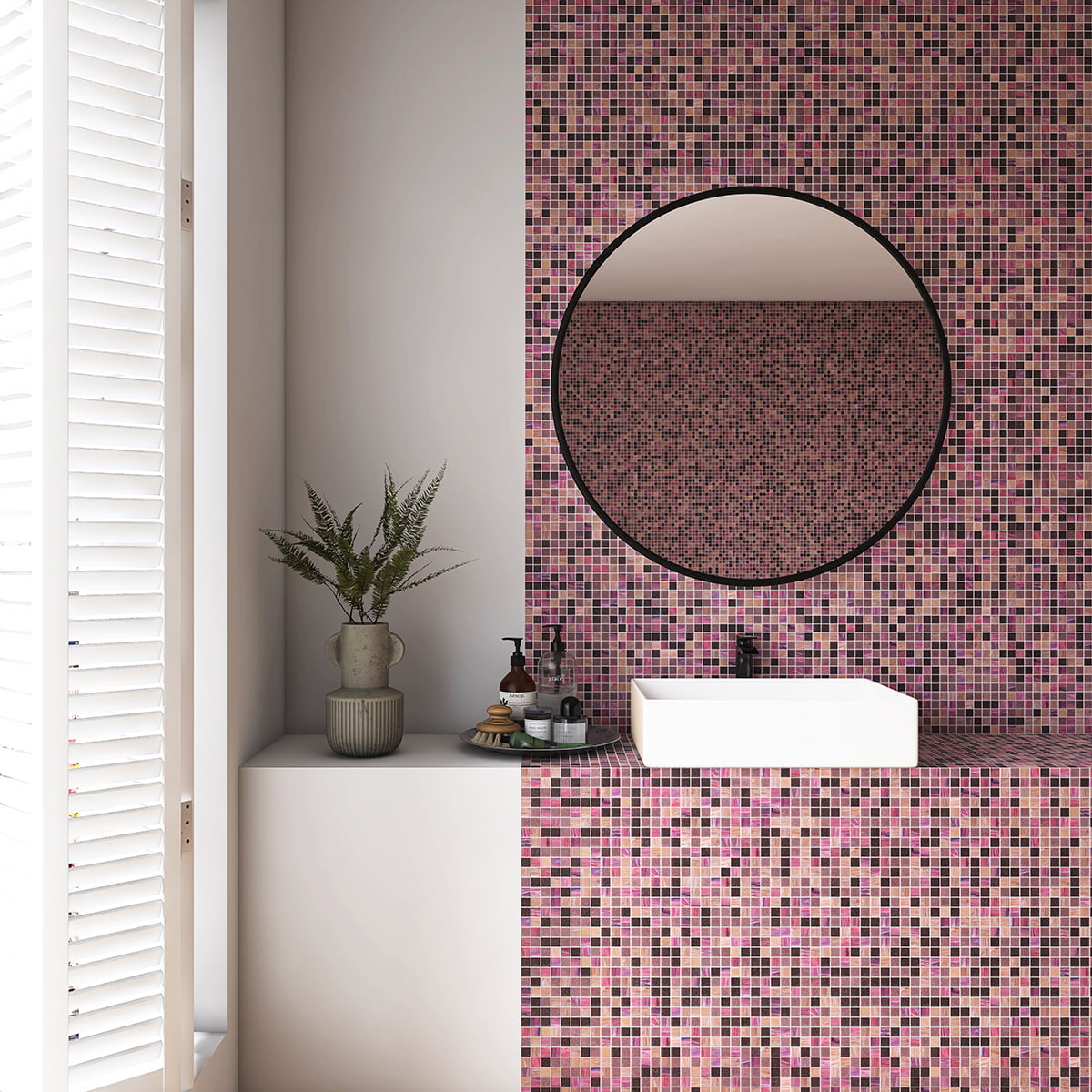 Bathroom with a round mirror and pink, purple, and brown mosaic tiles on the wall