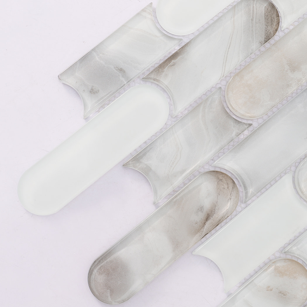 Detailed view of beige gray and white rounded linear glass mosaic tile pieces