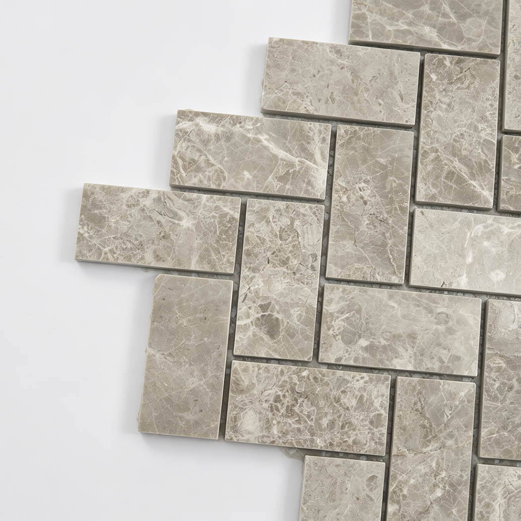 Close-up of beige marble herringbone mosaic tiles with natural stone variation