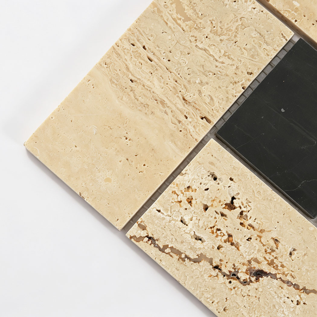 Close-up of beige travertine and black marble geometric mosaic tiles