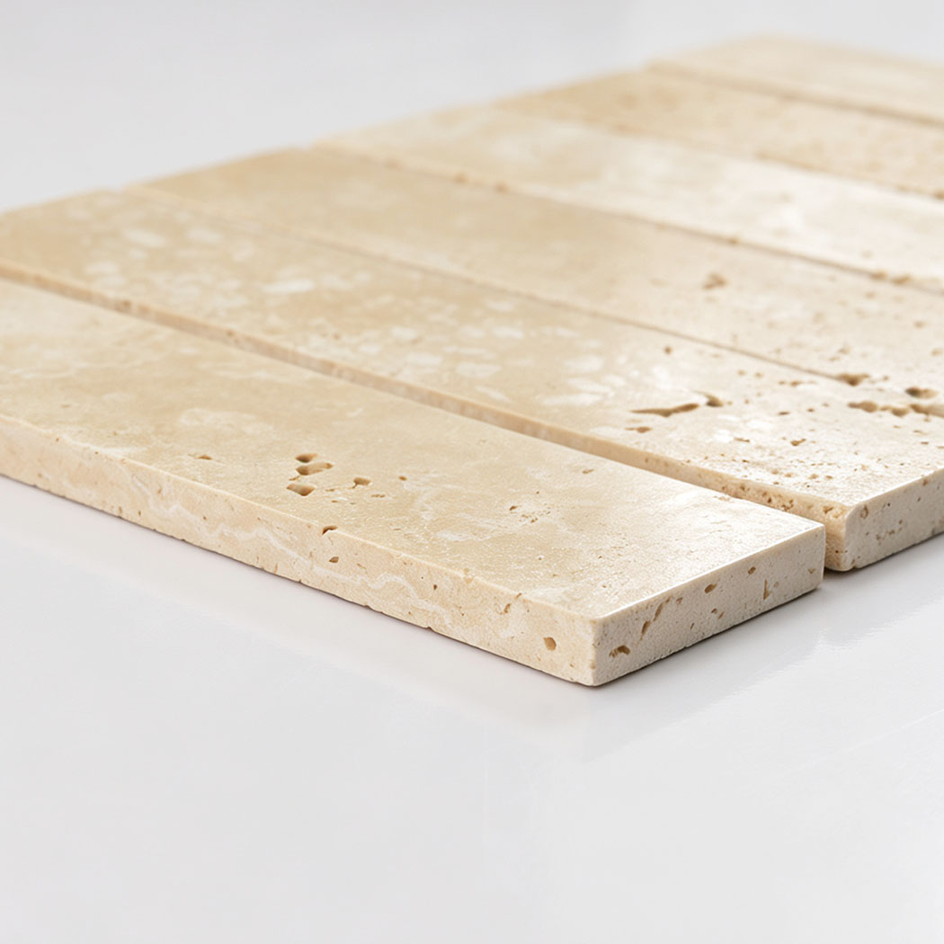 Side close-up of beige travertine strip tiles showing thickness and rounded edges