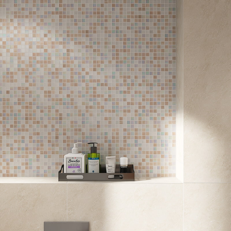 Beige and white mosaic tiles on the bathroom wall with personal care items on a shelf.